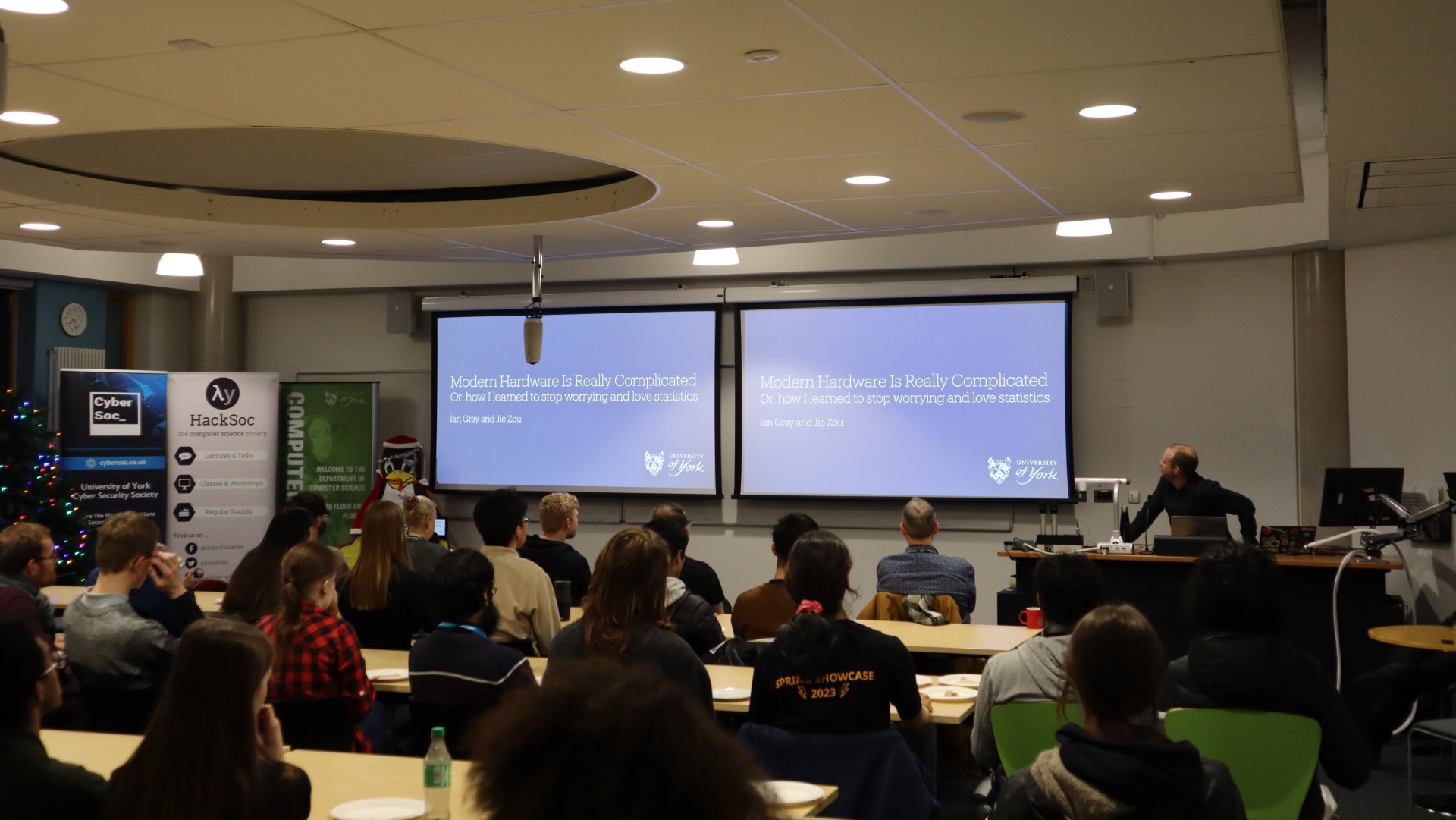 Photograph from Pub Lightning #1 of someone doing a presentation and a room full of people watching.